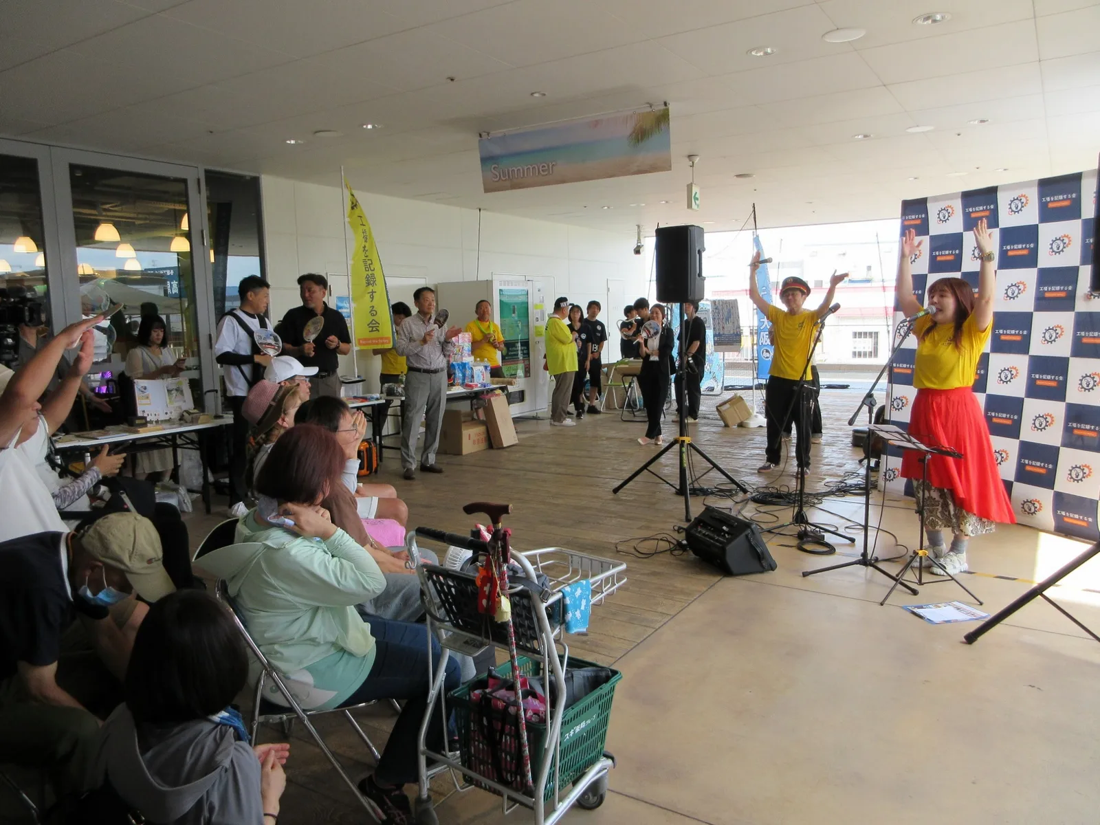 音楽ステージで歌う出演者と客席の来場者